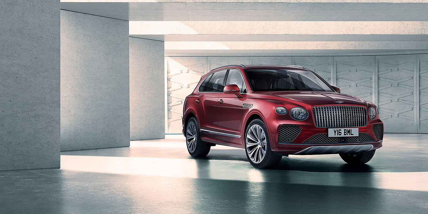 Bentley Ho Chi Minh Bentley Bentayga Atelier Edition SUV in Rubino Red paint front three quarter against textured concrete wall