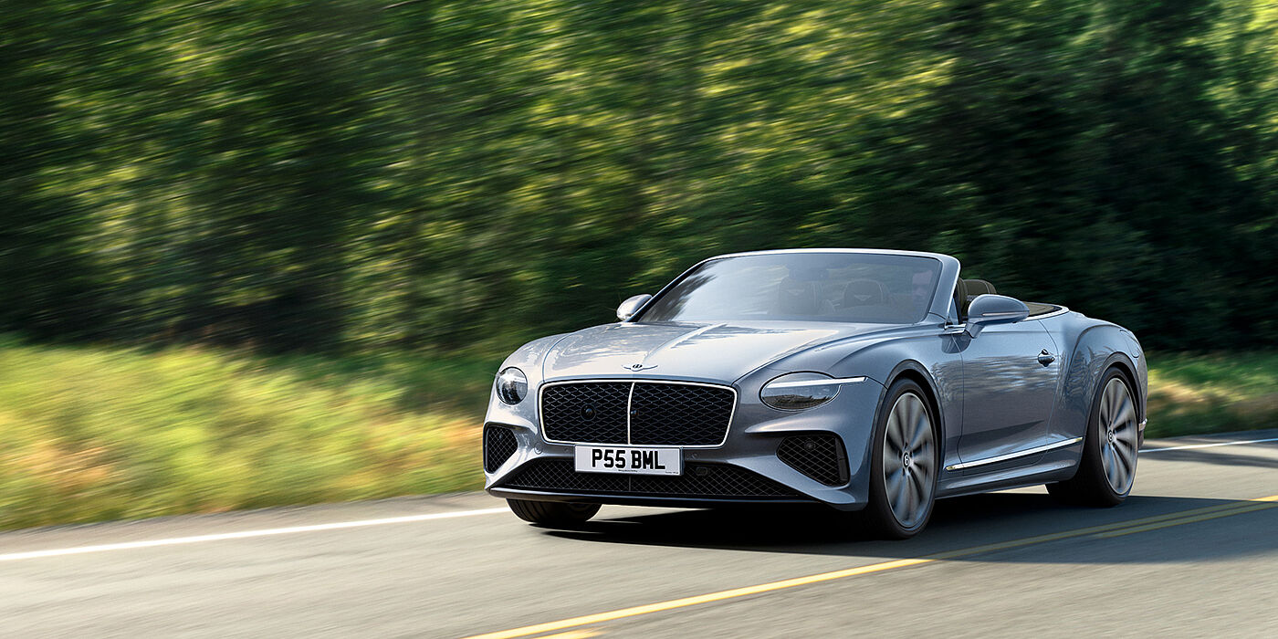 Bentley Ho Chi Minh New Bentley Continental GTC convertible front view in Silverlake paint with 22 inch ten spoke wheels, driving dynamically on a country road