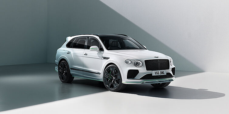 Xe Bentley Bentayga Speed SUV ở góc 3/4 với ngoại thất màu trắng Glacier White, điểm nhấn màu xanh lá Hyper Green ở cản trước, viền lazang và nắp gương – tạo dấu ấn cá tính mạnh mẽ cho chiếc SUV hiệu suất cao mang phong cách thể thao.