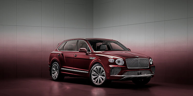 %dealerCompanyName% Bentley Bentayga EWB SUV in 3/4 view with Rubino Mulliner heritage exterior paint, Atelier Edition version, showcasing refinement and elegance.