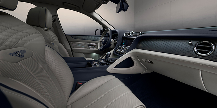 Bentley Bentayga EWB SUV interior detail with Linen and Imperial Blue leather, diamond-knurled brushed aluminium dashboard and window trim, Atelier Edition