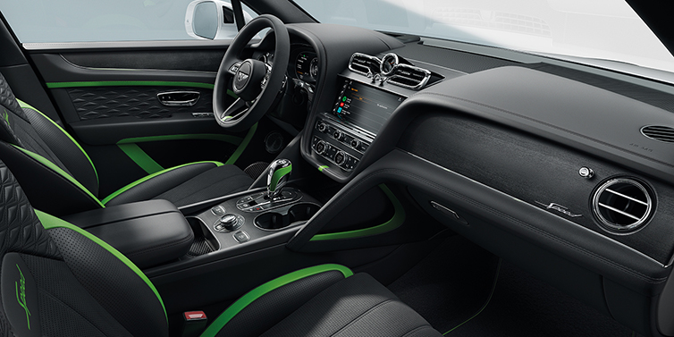 Khoang lái Bentley Bentayga Speed với chi tiết nội thất màu đen phối chỉ và viền xanh lá Hyper Green đặc trưng, cần số thể thao, màn hình giải trí cảm ứng tích hợp Apple CarPlay, và logo “Speed” trên táp-lô ốp gỗ cao cấp.